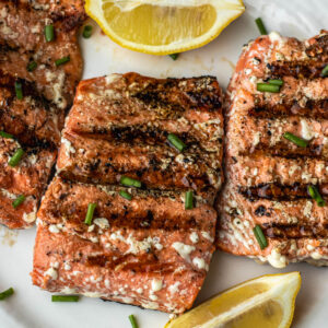 Grilled Sockeye Salmon steaks on a white plate.