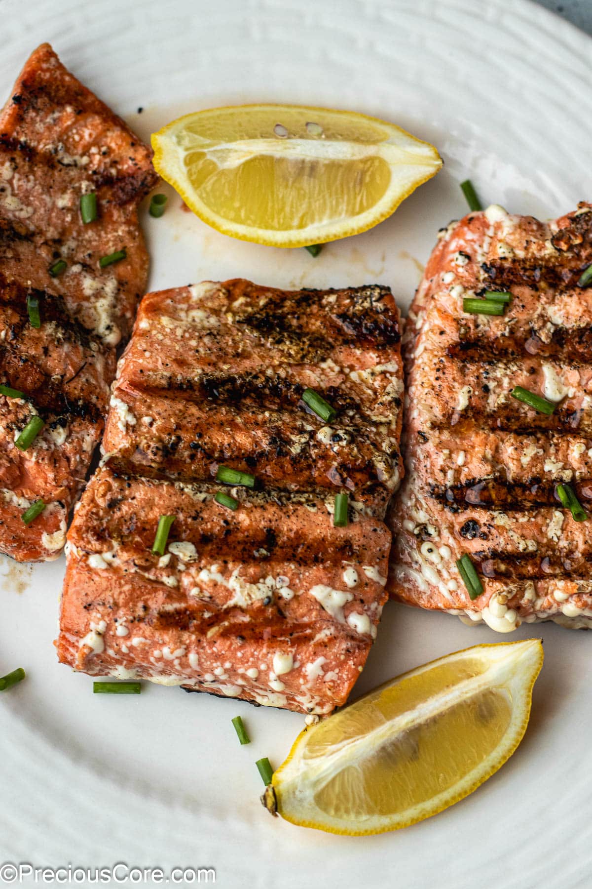 Grilled Sockeye Salmon steaks on a white plate.