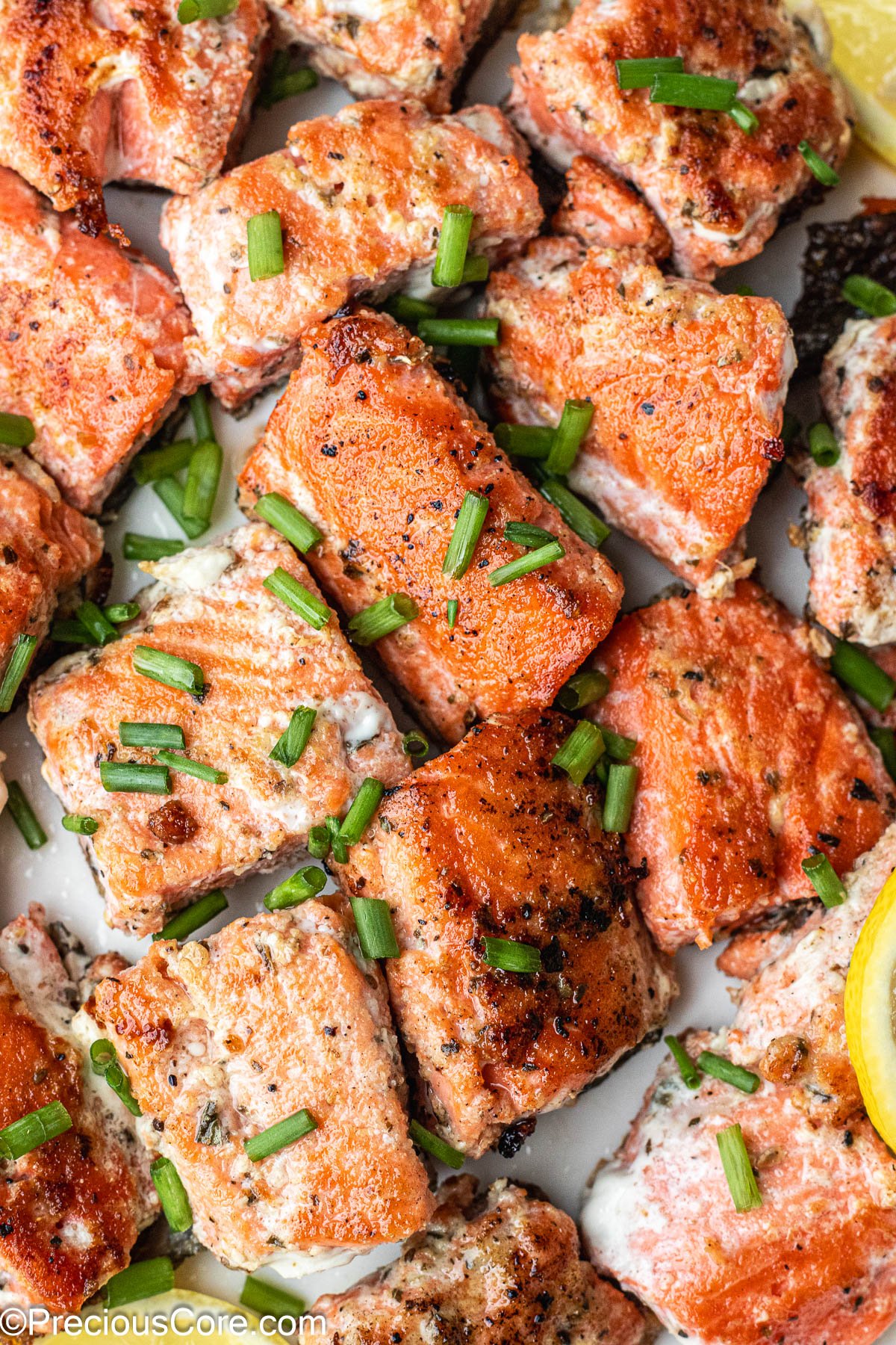 About 1-inch sized salmon bites on a white plate.