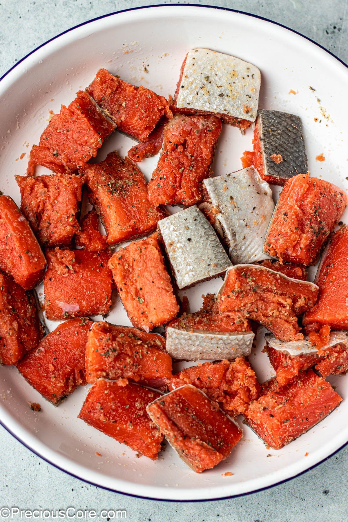 Seasoned salmon in a bowl.