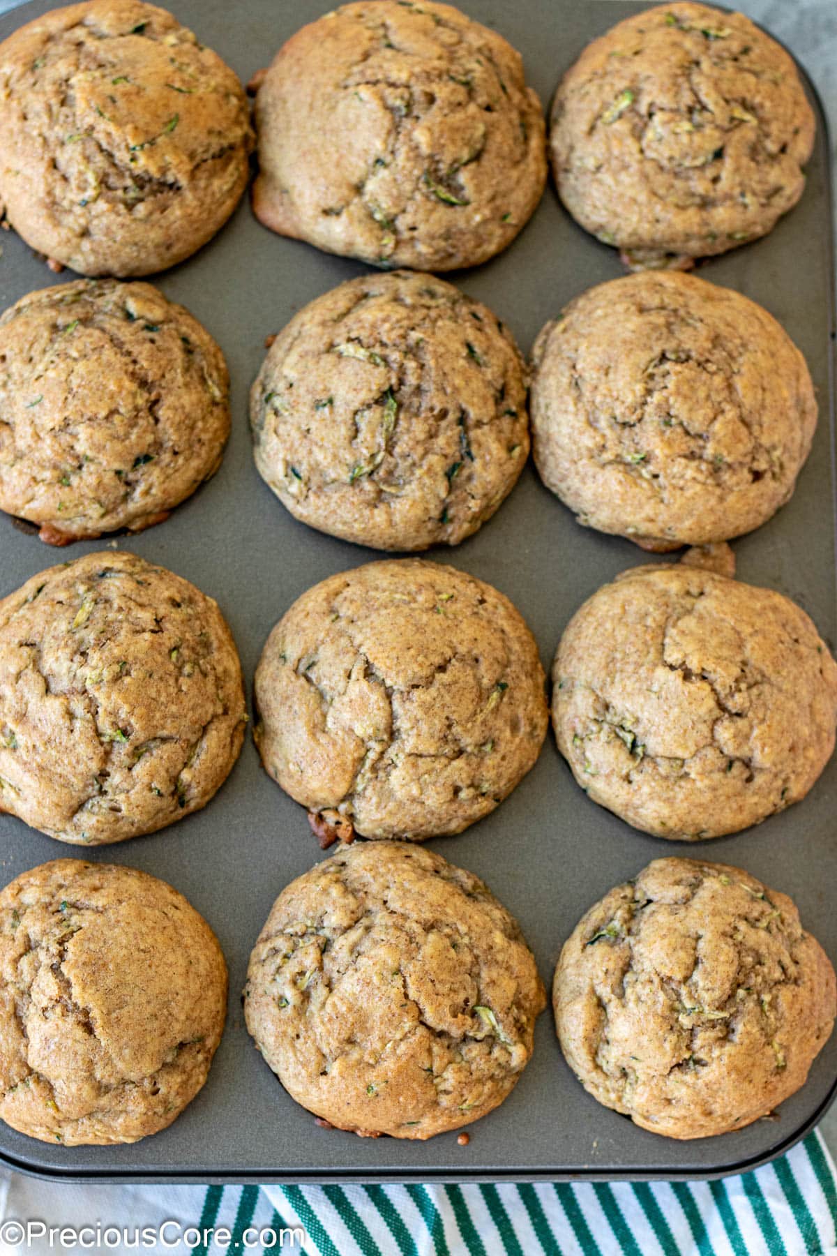 Baked zucchini muffins with applesauce in muffin tin.