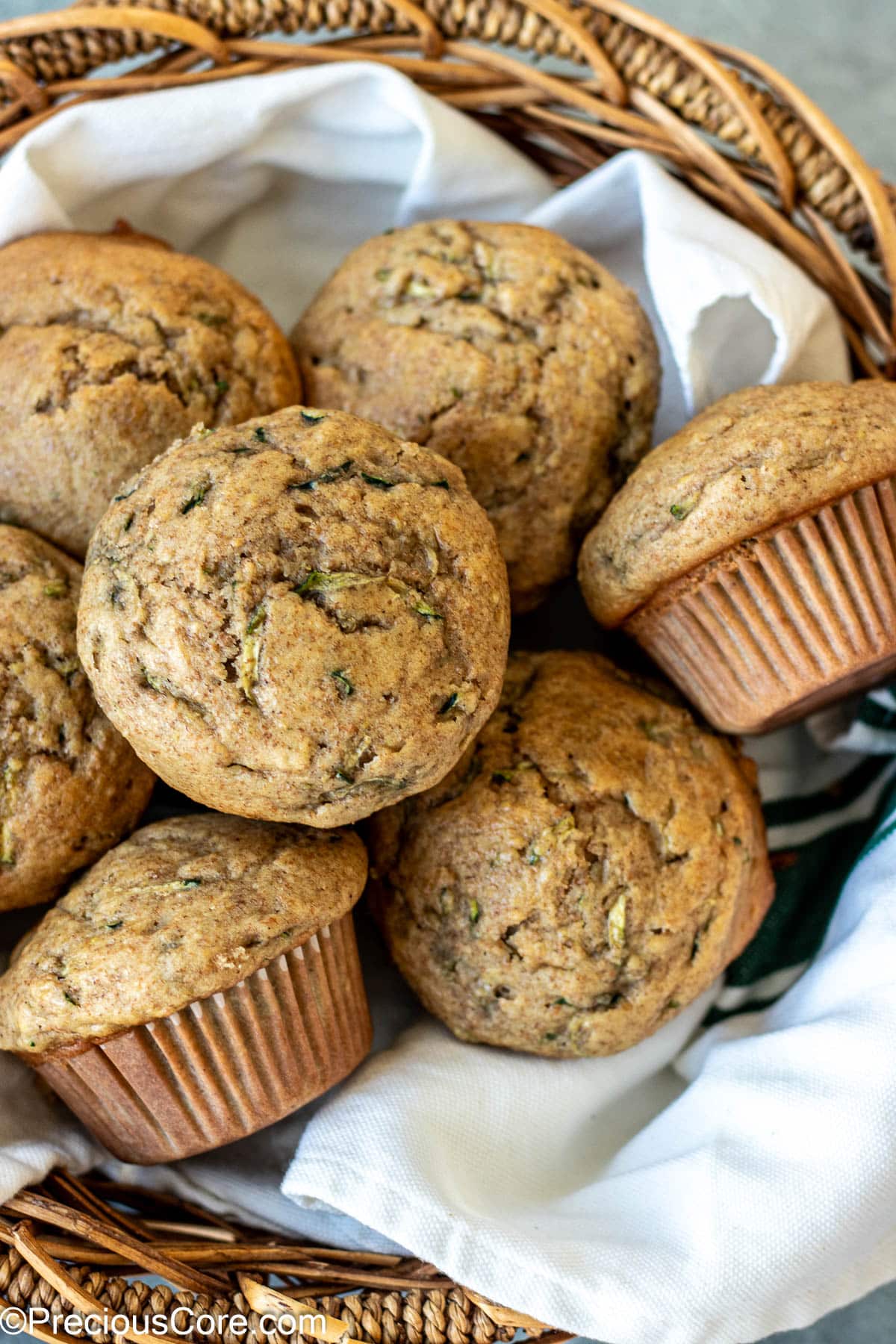 Muffins in a basket lined with a kitchen cloth.