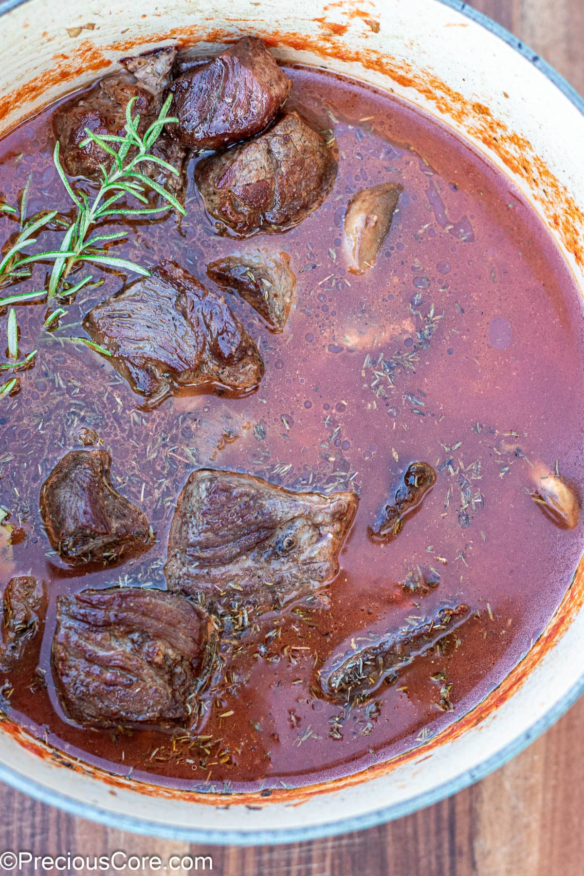 Dutch oven with beef, broth, crushed tomatoes.