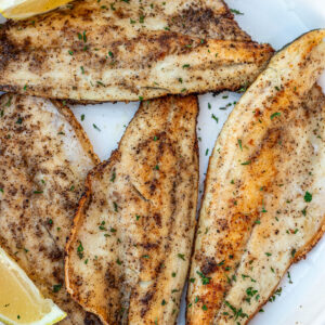 Pan Seared Sea Bass filets on a white plate.