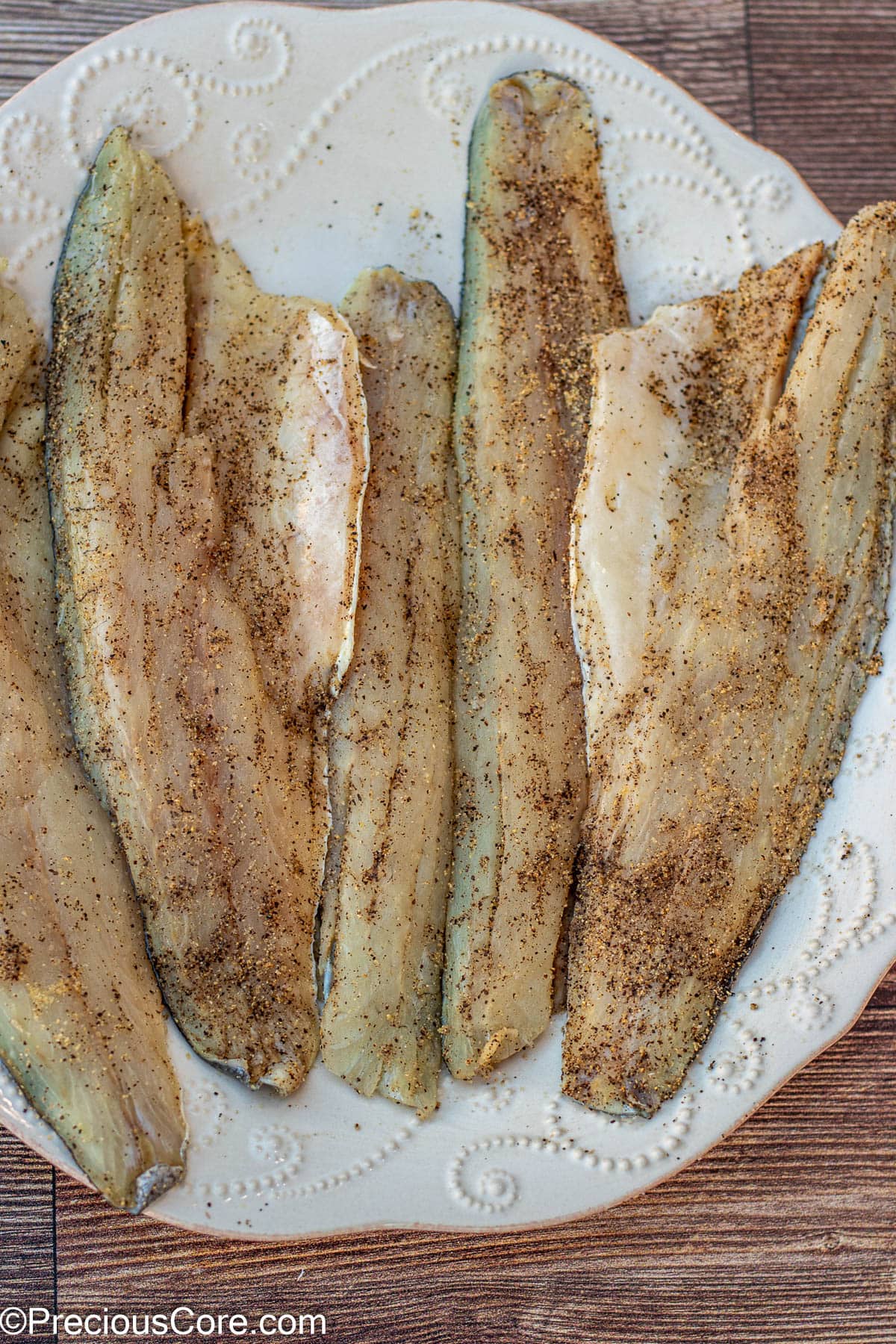 Seasoned sea bass on a large plate.