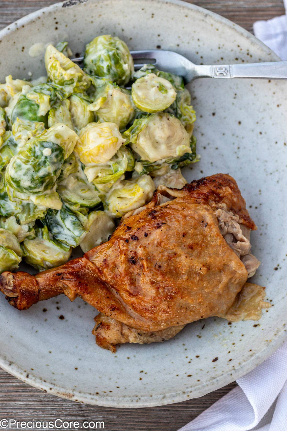 Duck in a bowl with brussels sprouts.
