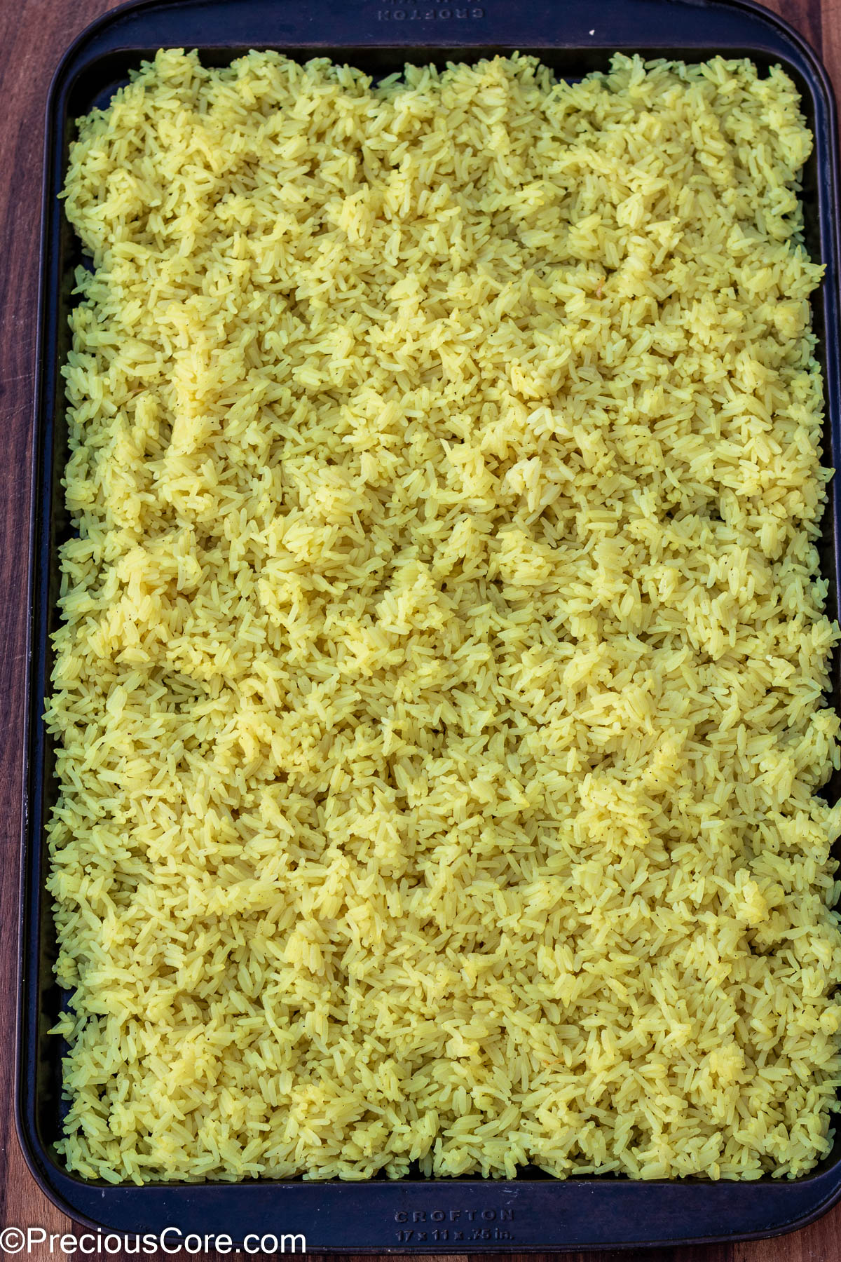 Cooked rice spread on a tray.