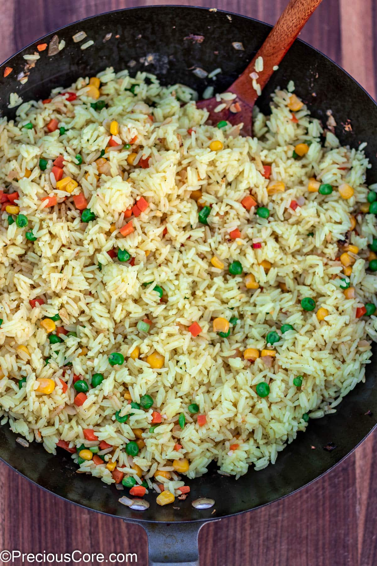 Rice stir-fried with vegetables in a wok.