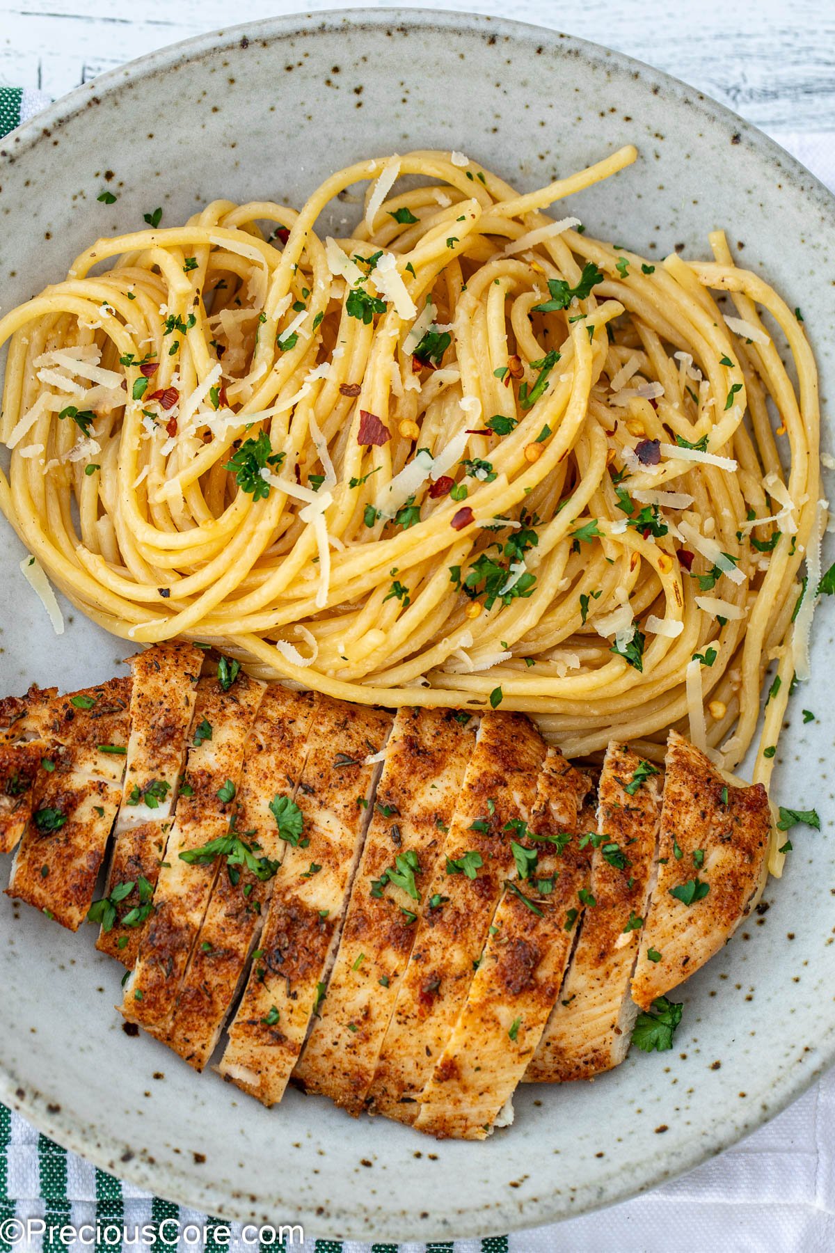 Garlic butter pasta and cooked chicken breasts in a bowl.