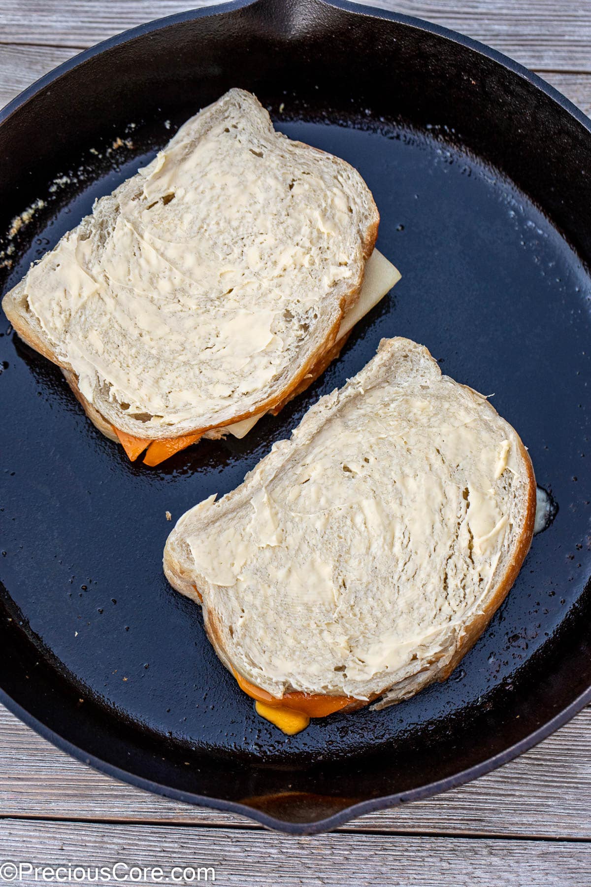 Grilled cheese cooking in cast iron skillet.