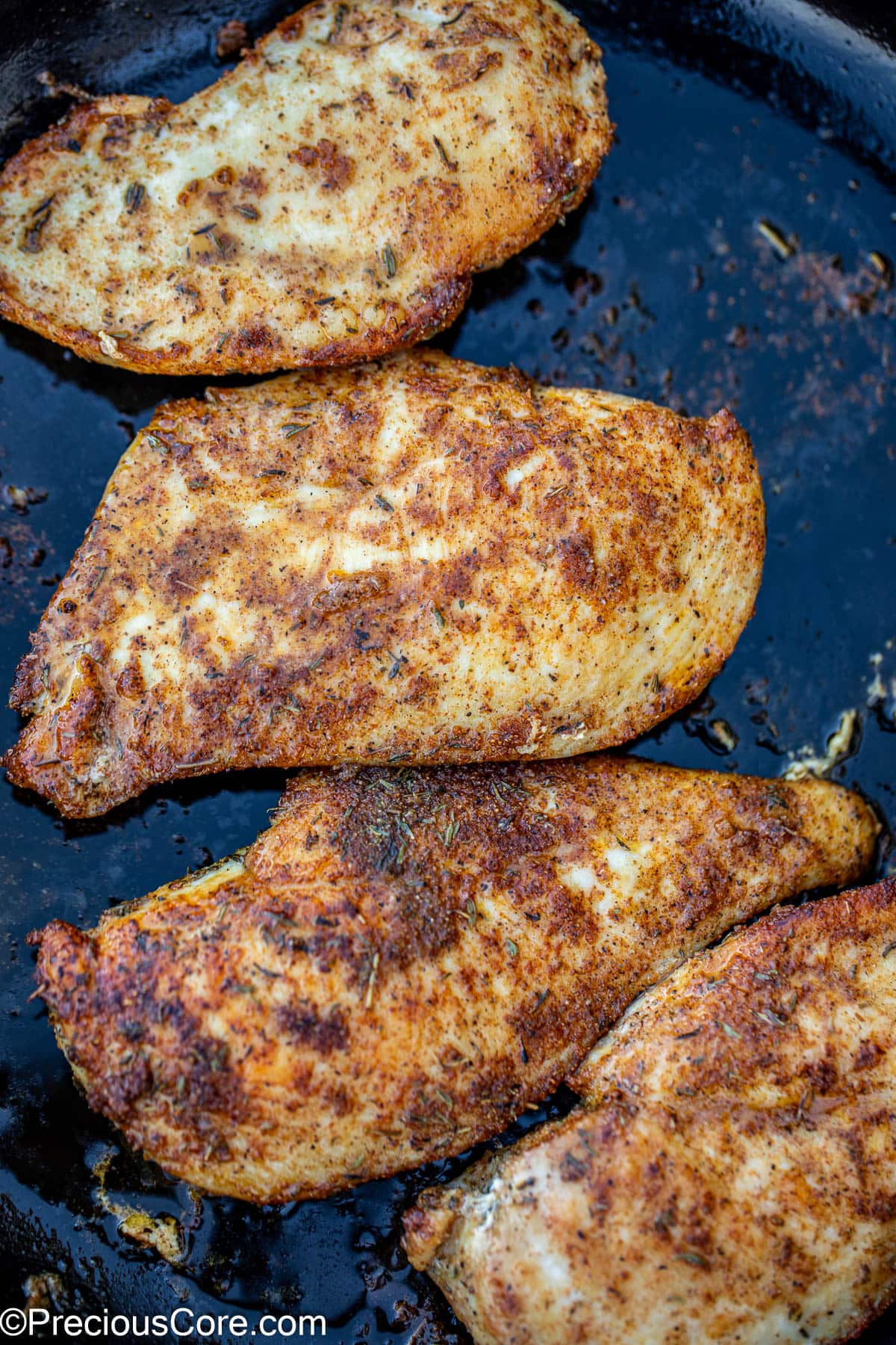 Seared thin sliced chicken breasts in skillet.