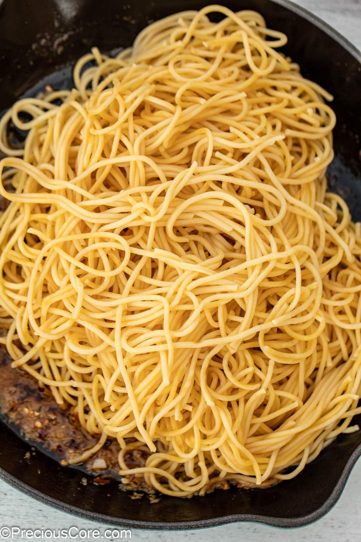 Spaghetti in cast iron pan with garlic sauce.