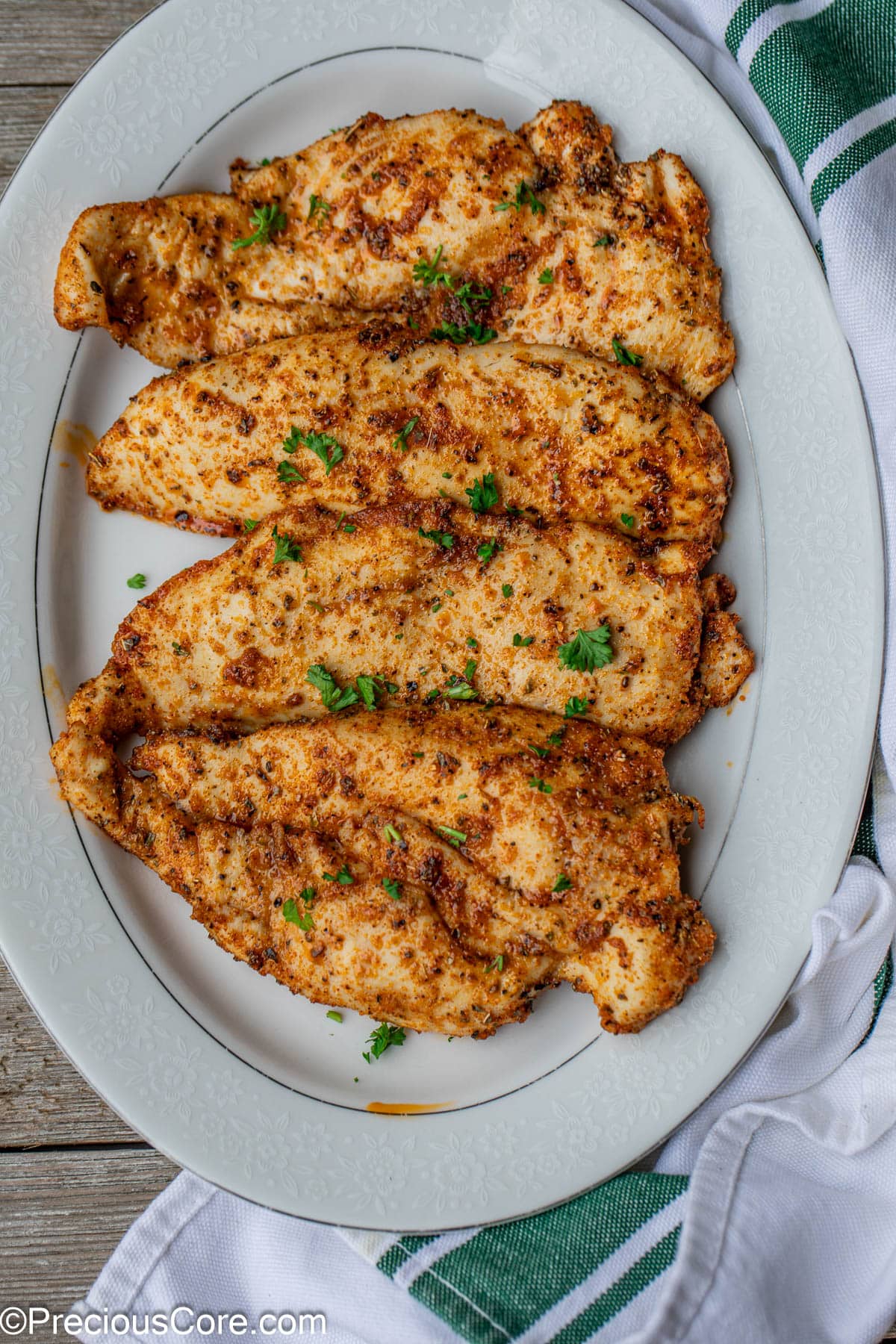 Cooked chicken on white serving plate.