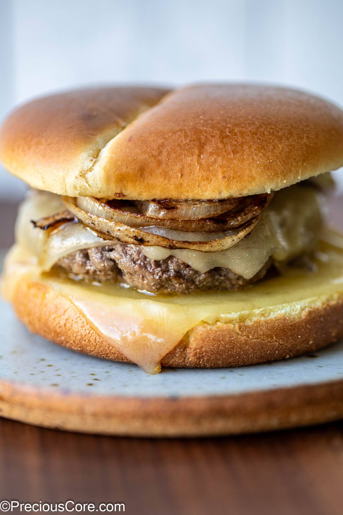 A grilled onion cheddar burger on a plate.