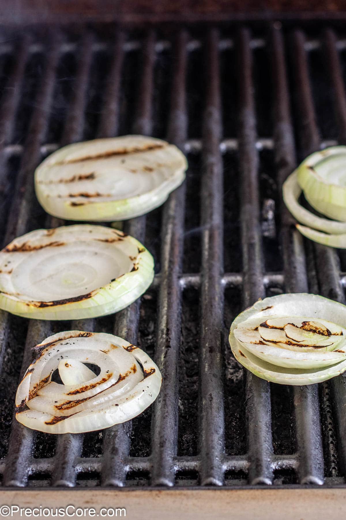 Round slices of onions on a grill.