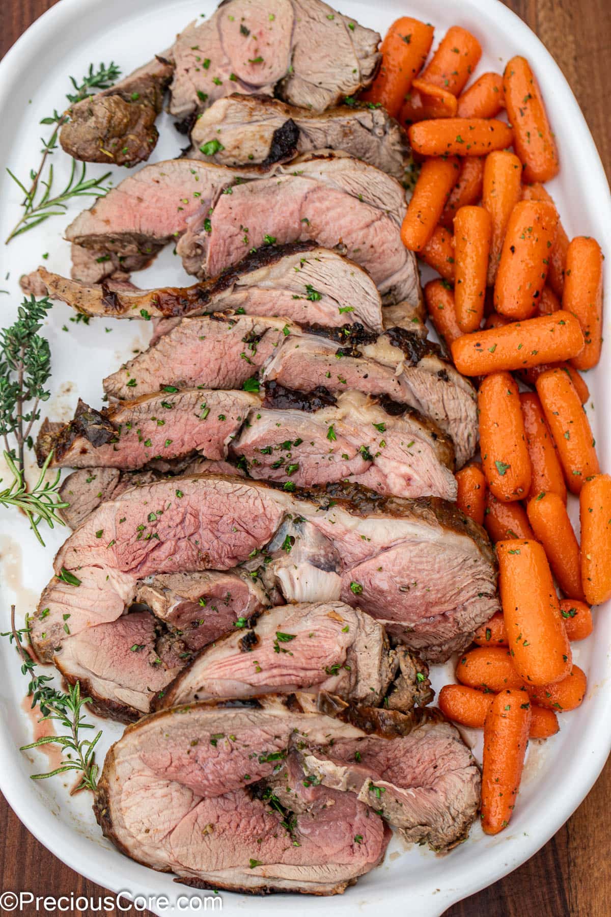 Sliced roast and glazed carrots on white tray.