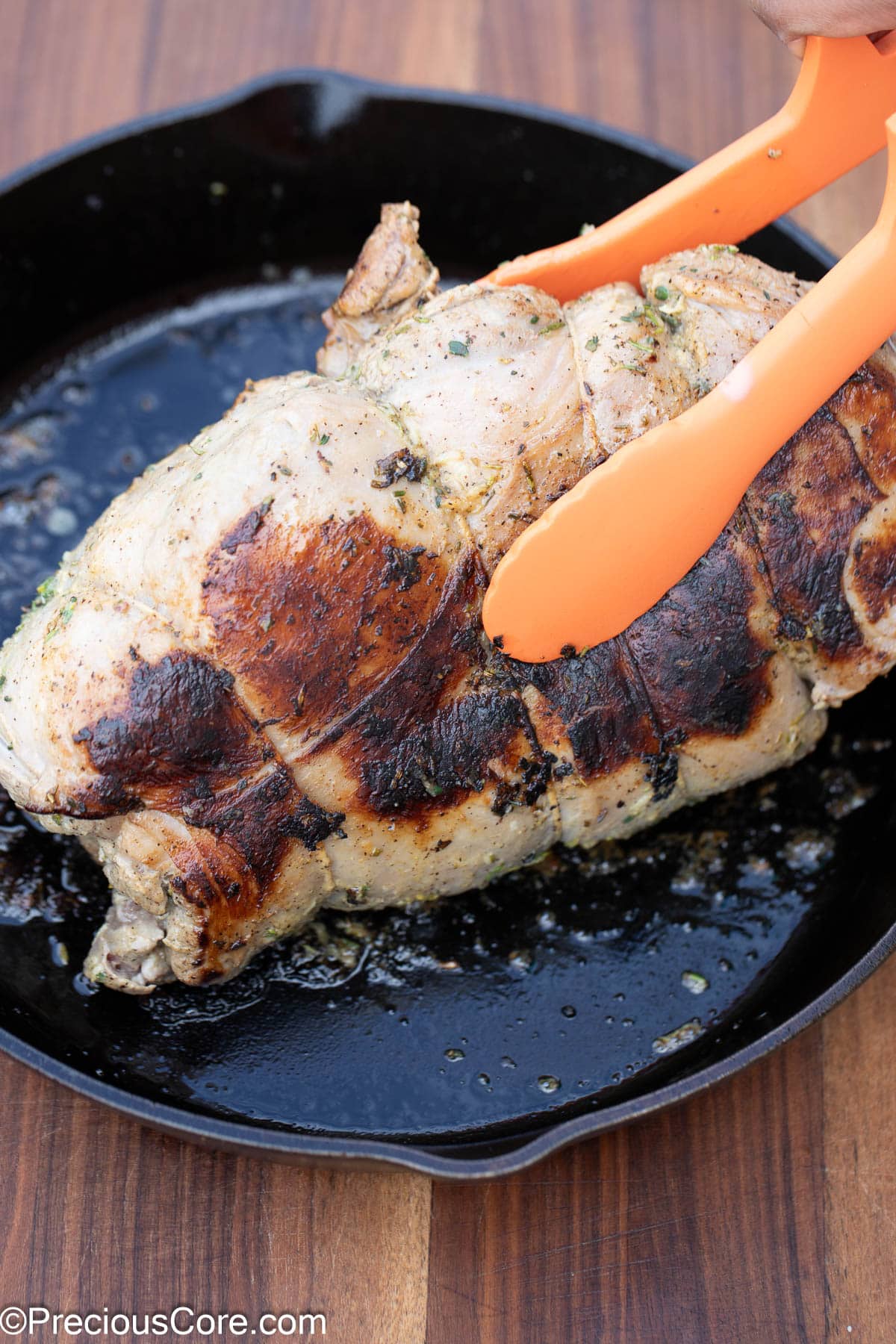 Searing the sides of boneless lamb leg.