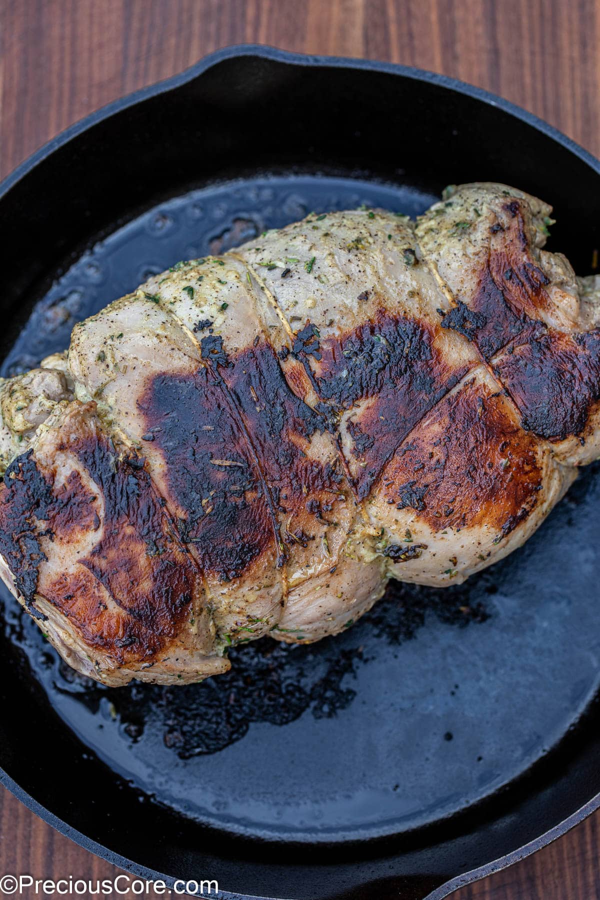 Seared lamb in cast iron skillet.