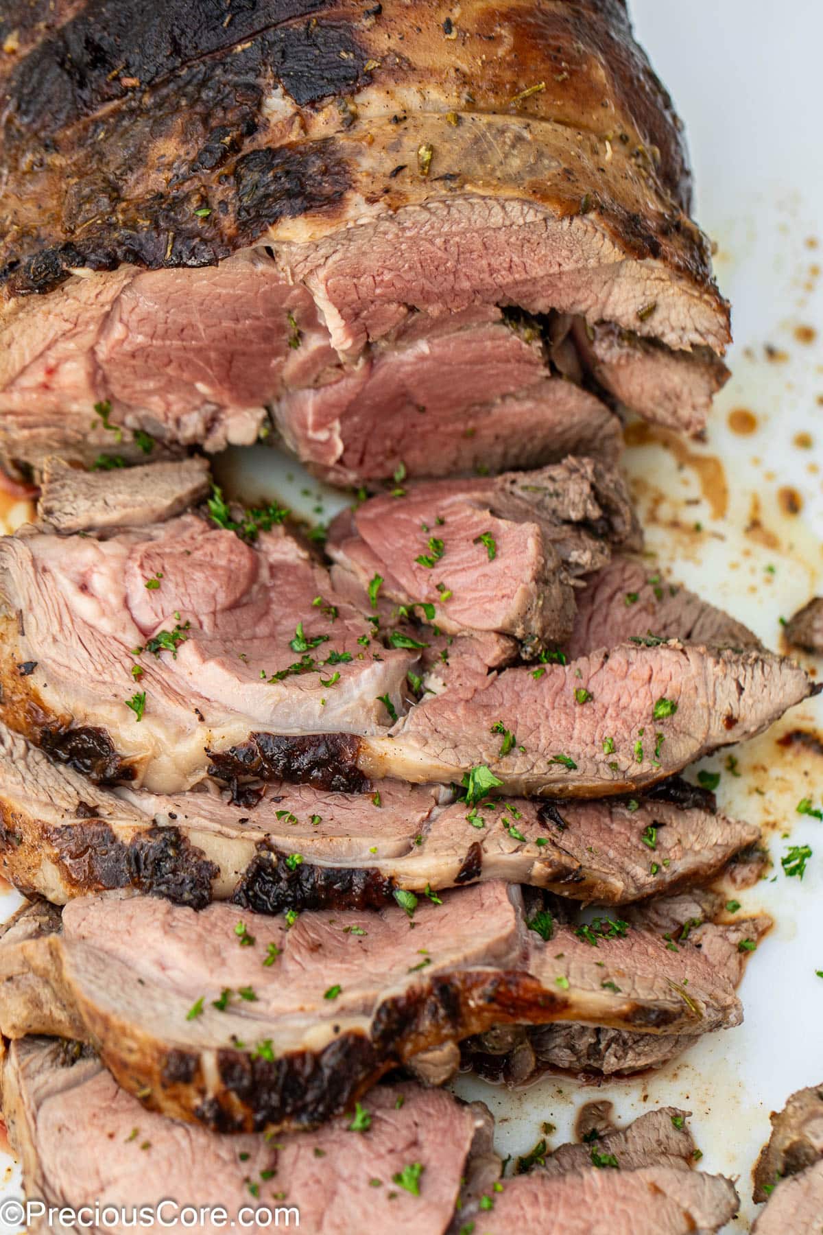 A sliced roasted boneless leg of lamb.