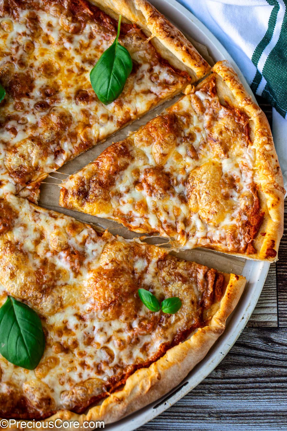 Side shot of easy homemade pizza with a little cheese pull.