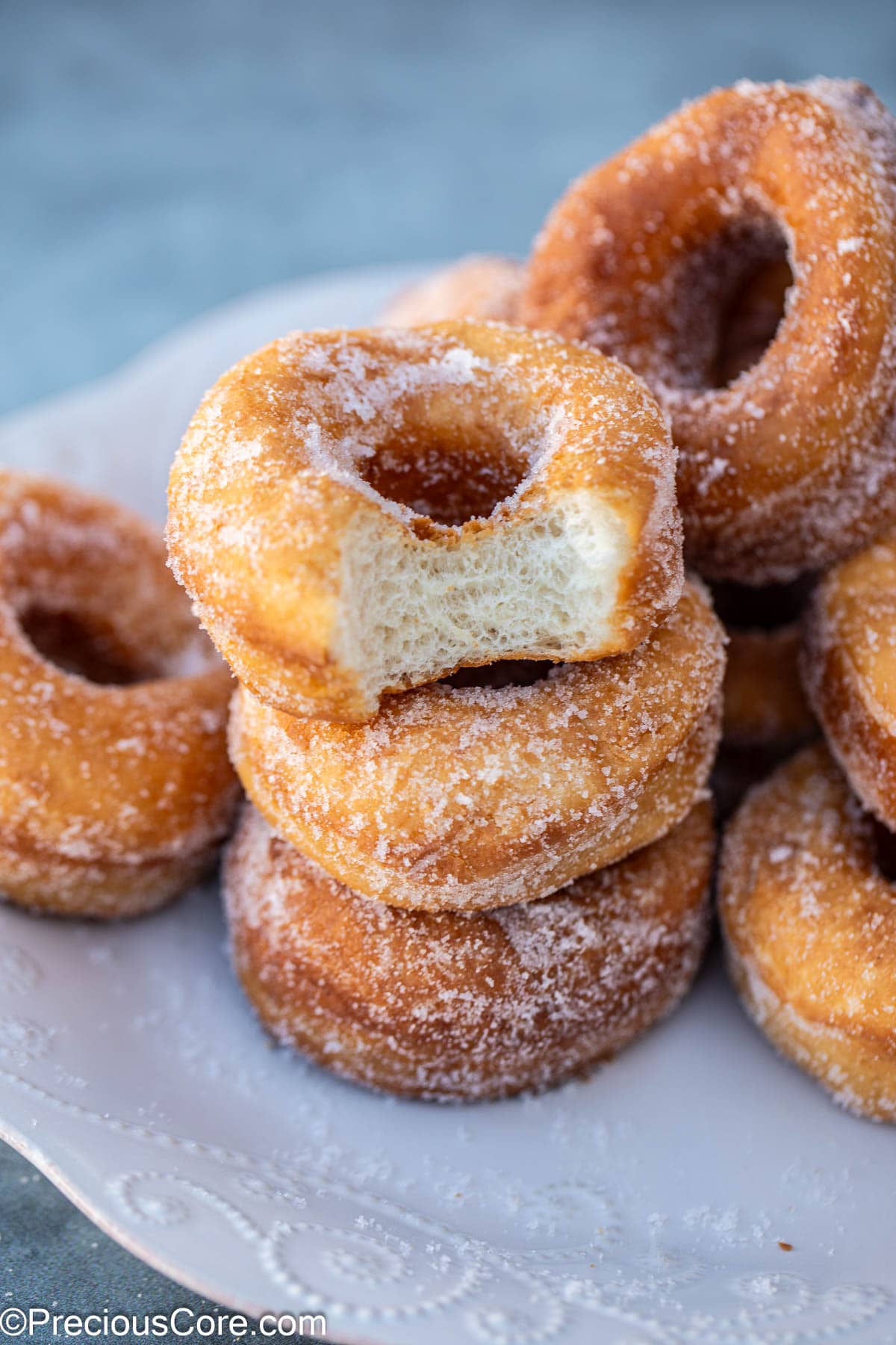 Stack of doughnuts with one missing a bite.