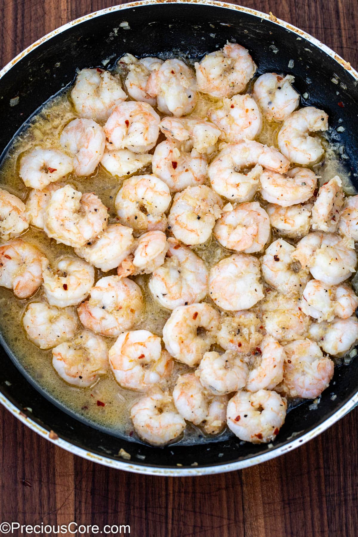 Cooked shrimp in a skillet with white wine sauce.