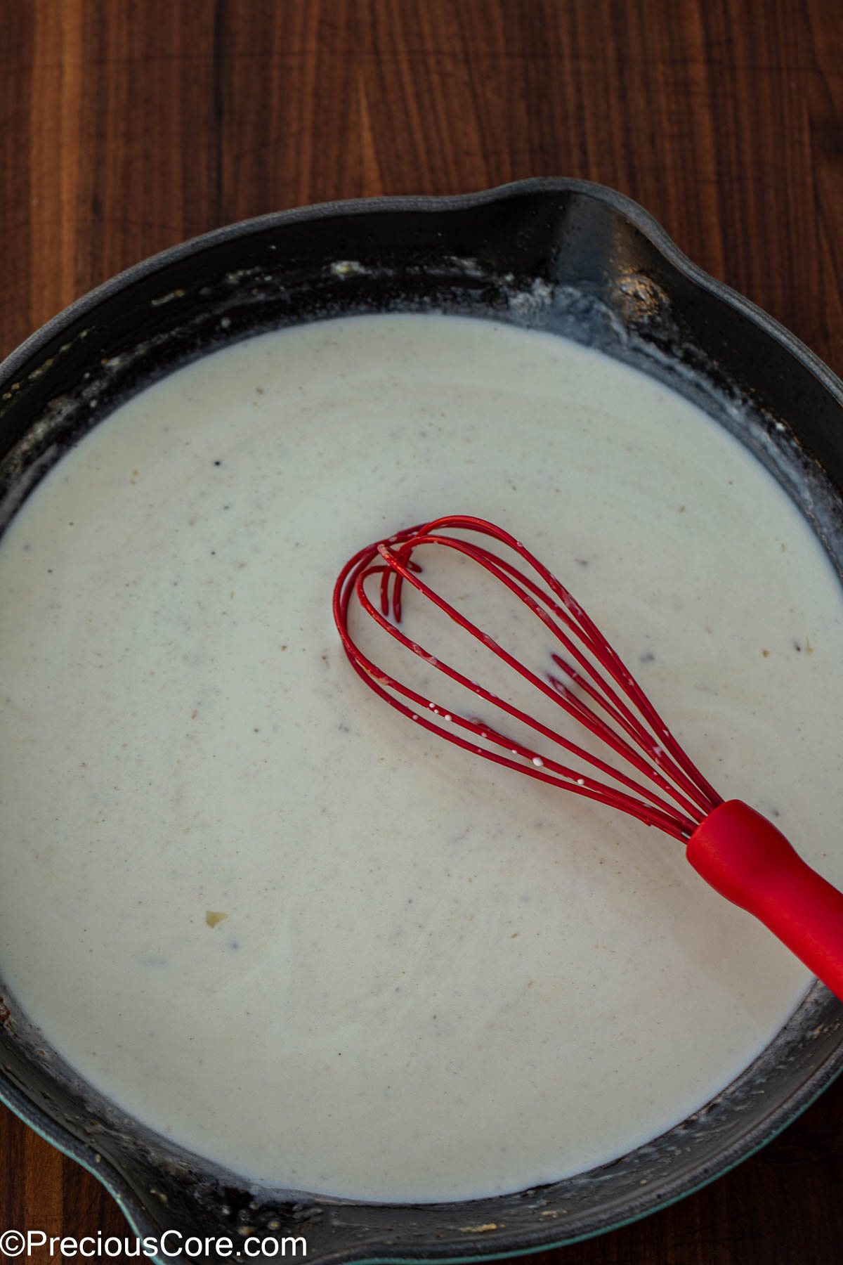 White sauce cooking in a pan.