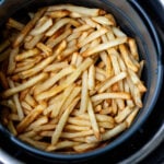 Air fried fries in round air fryer basket.