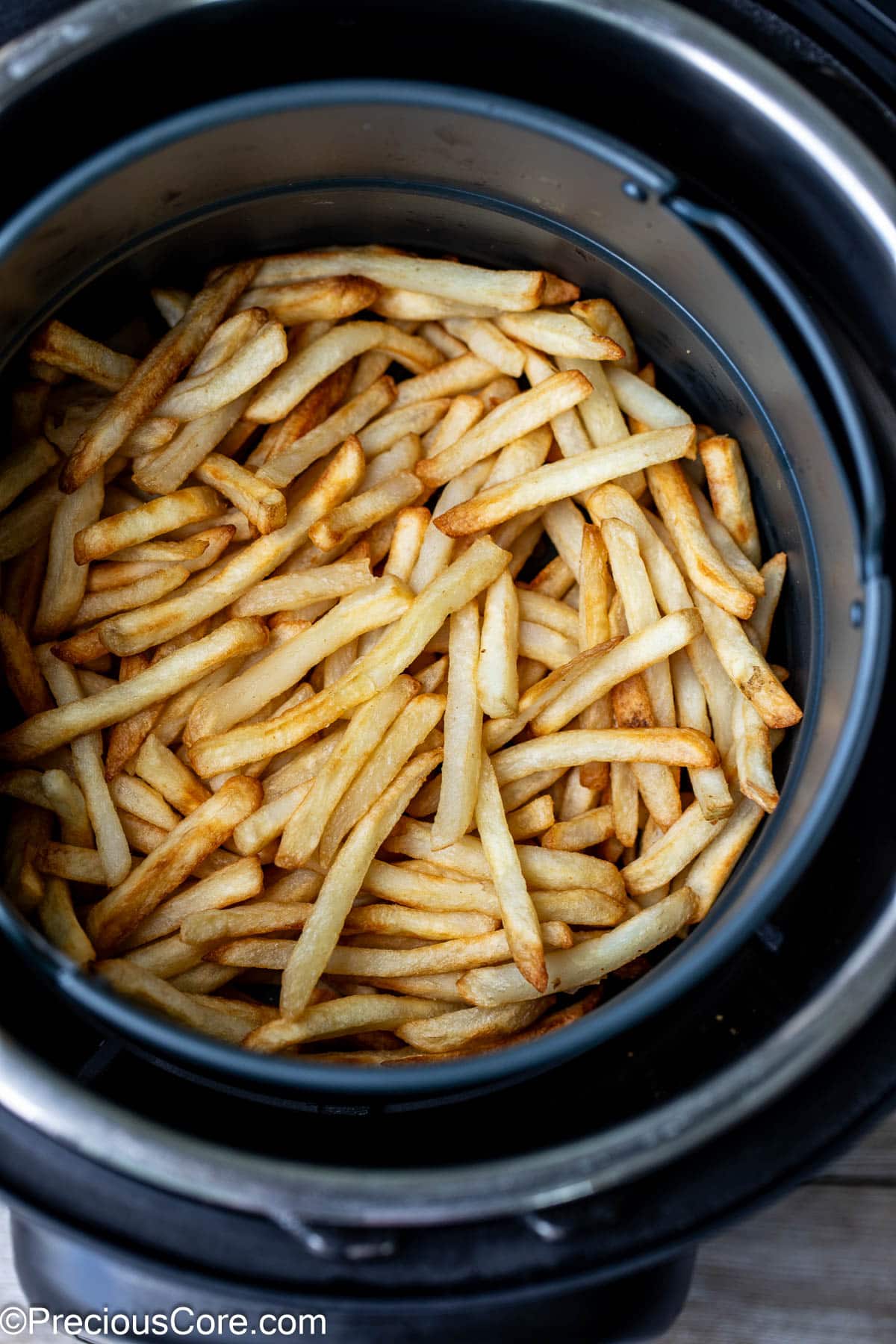 Air fried fries in round air fryer basket.
