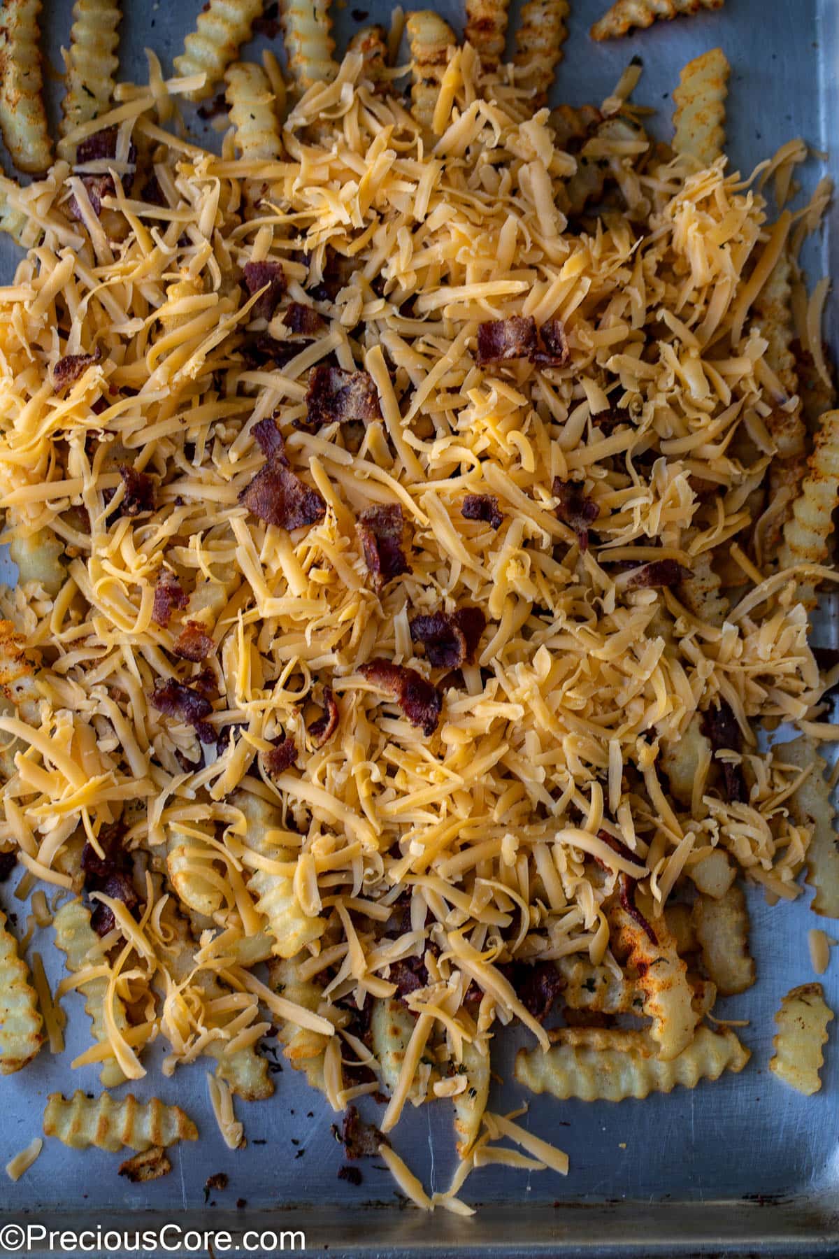 Fries topped with shredded cheddar and bacon.