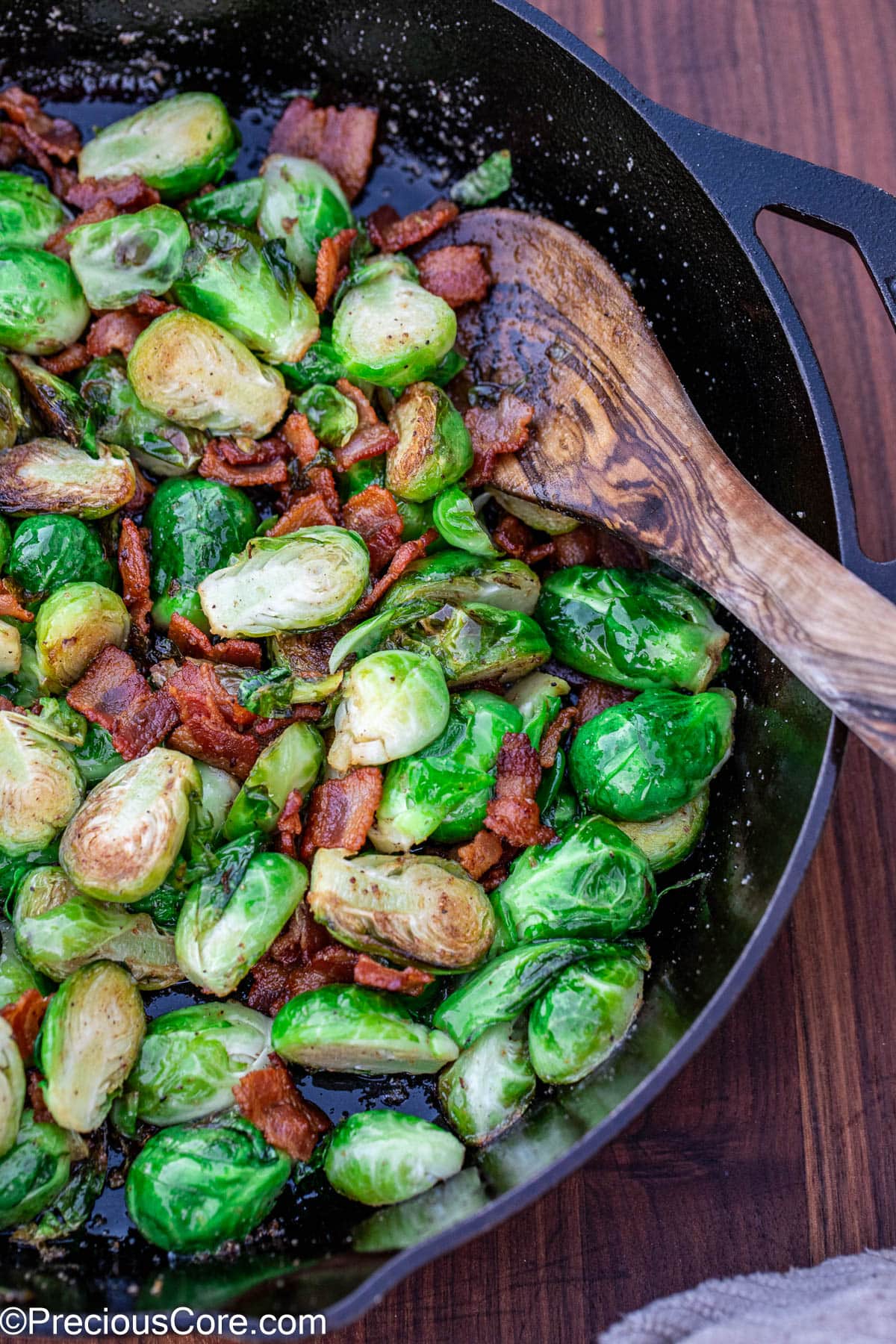 Cooked bacon with Brussels sprouts in a skillet.