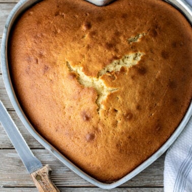 Heart shaped baked cake and a knife.