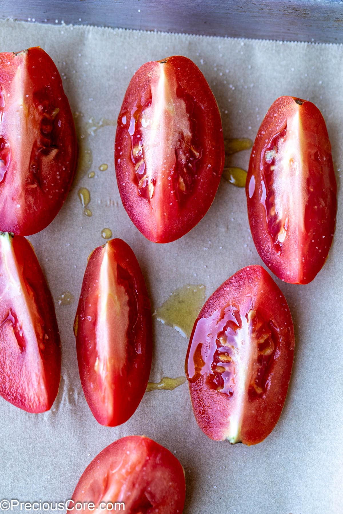 Tomato quarters drizzled with olive oil and sprinkled with salt.