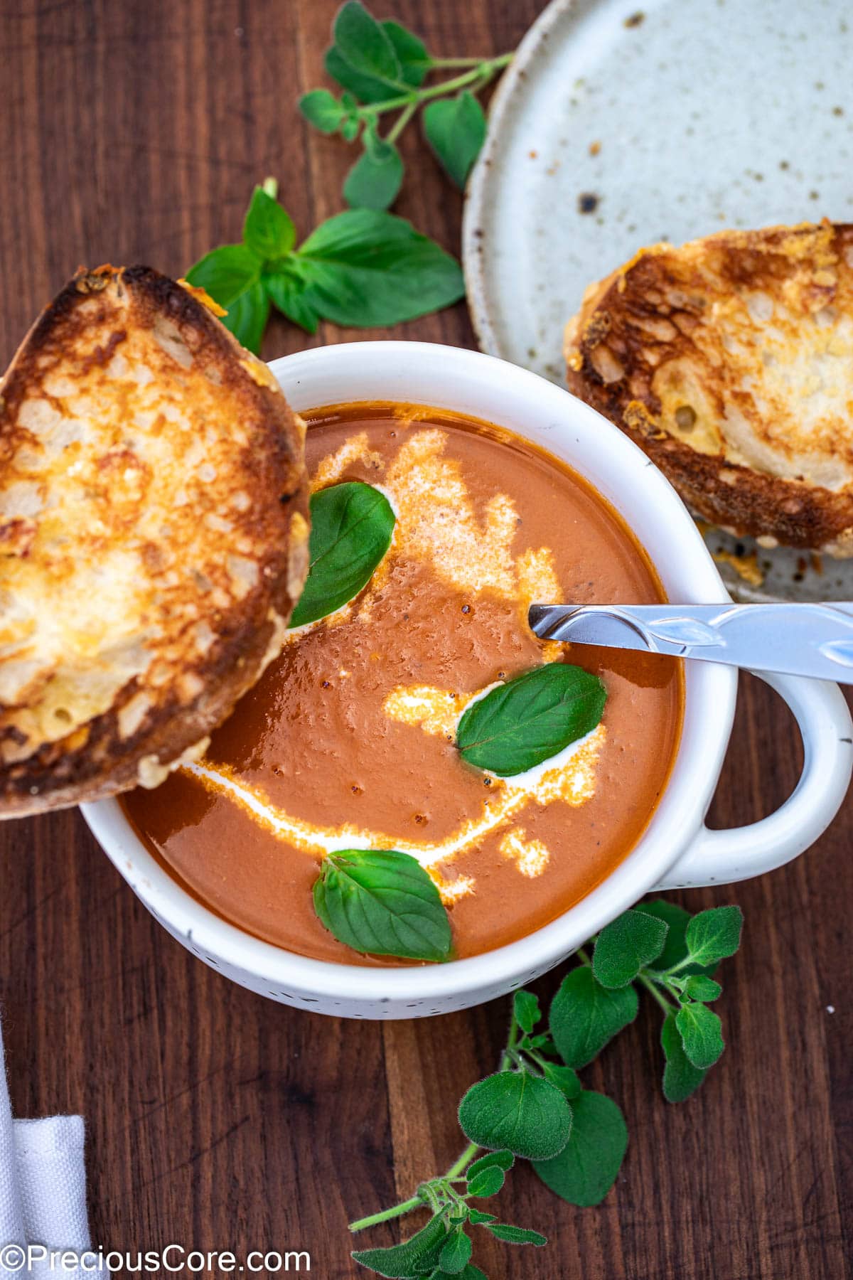 Cozy bowl of tomato soup with heavy cream drizzled on top.