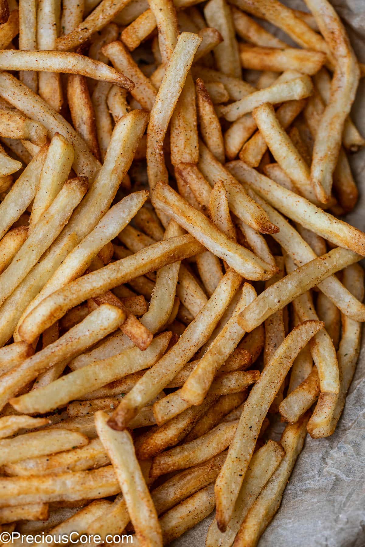 Fries with some seasoning sprinkled on top.