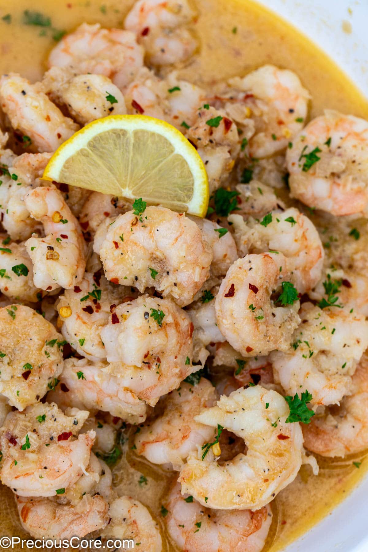 Close up shot of cooked shrimp garnished with a lemon slice.