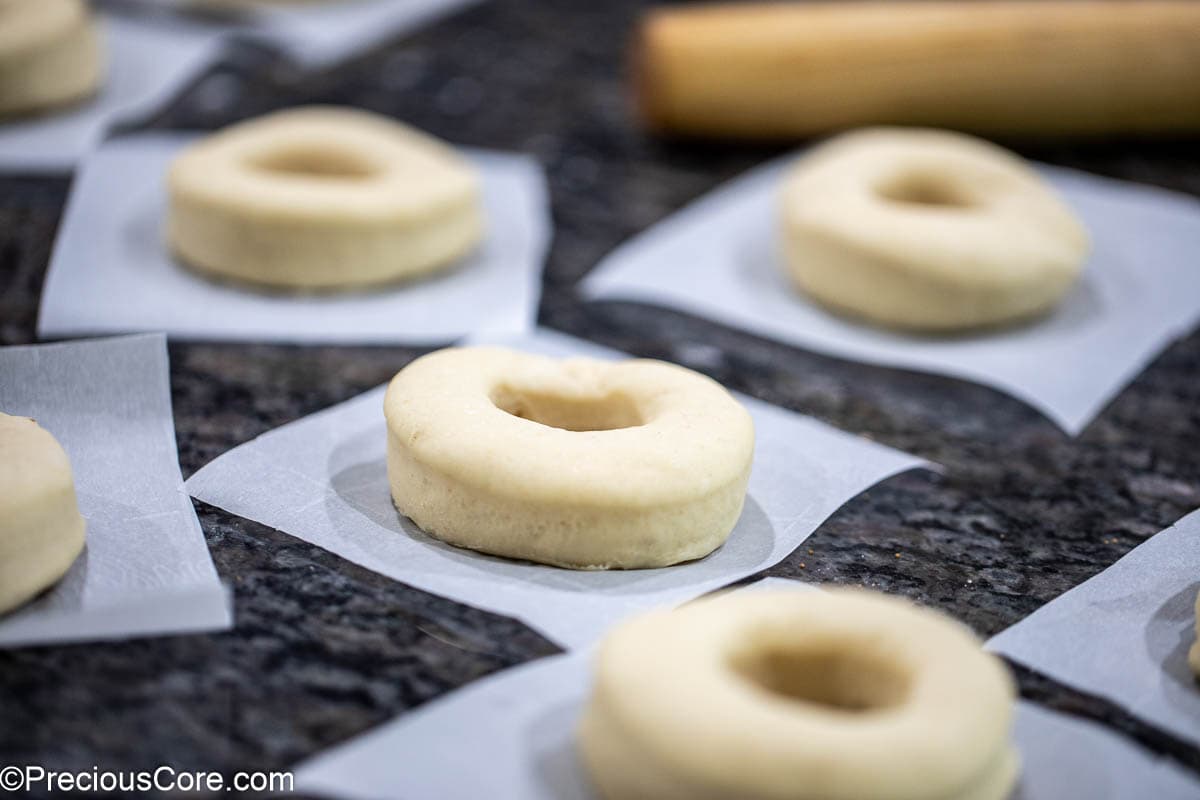 Cut out donuts on parchment paper squares.