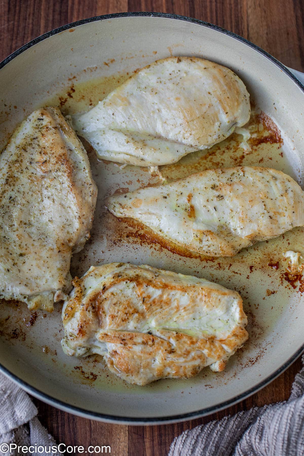 Cooked chicken breasts in a cast iron pot.