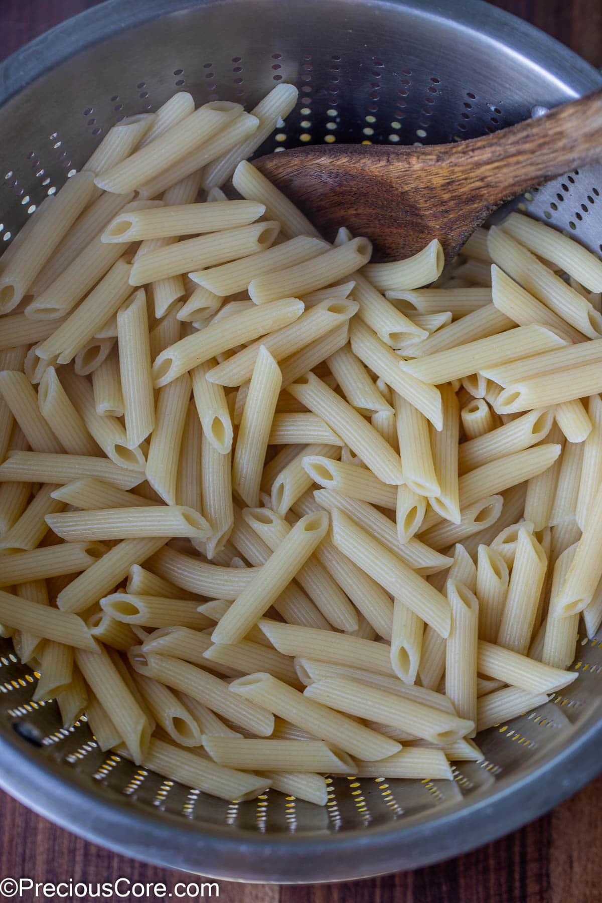 Drained cooked pasta in a stainless steel colander.