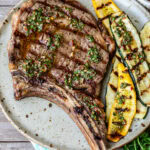 Bone-In Ribeye steak on a plate served with grilled zucchini.