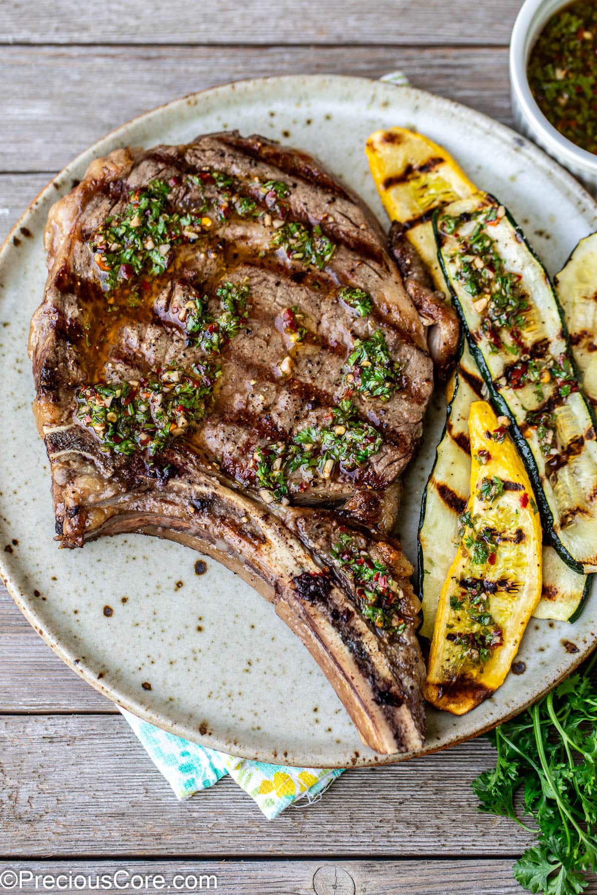 Bone-In Ribeye steak on a plate served with grilled zucchini.