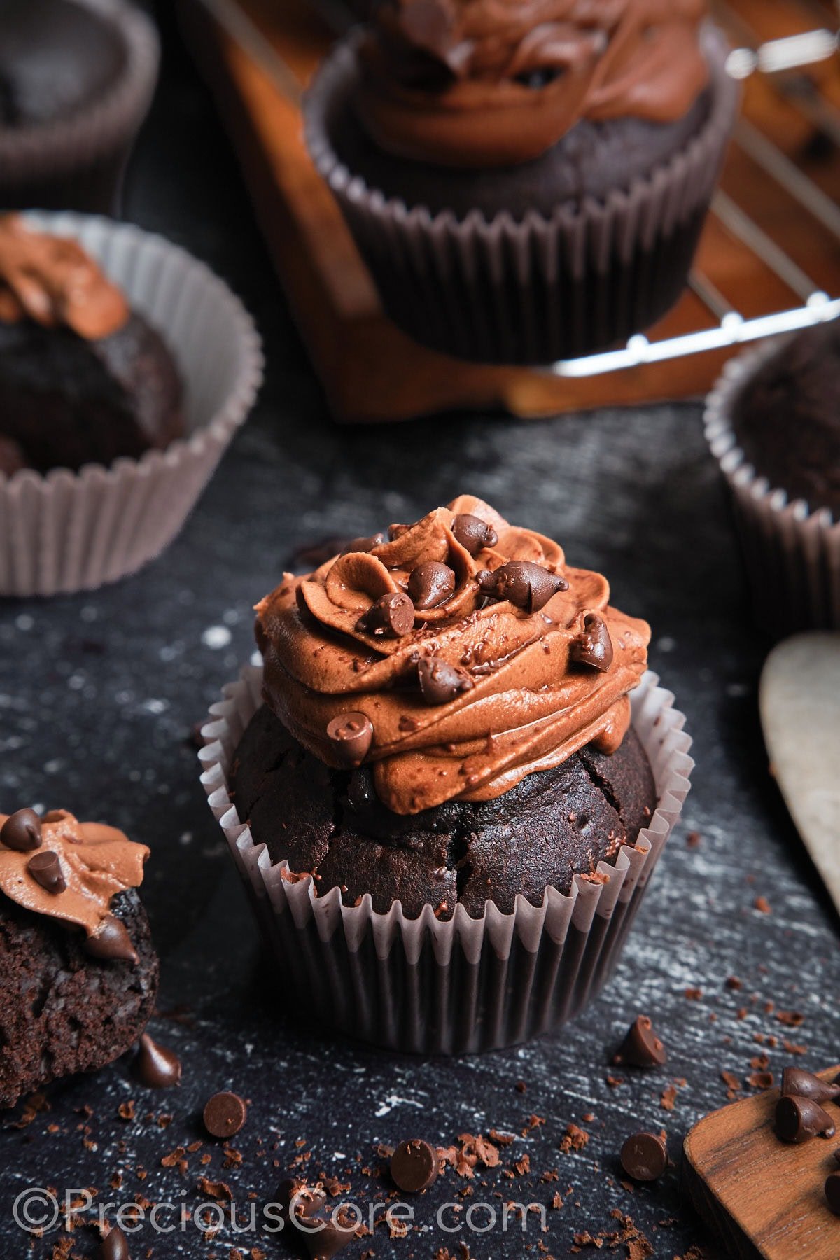 A frosted chocolate cupcake topped with chocolate chips.
