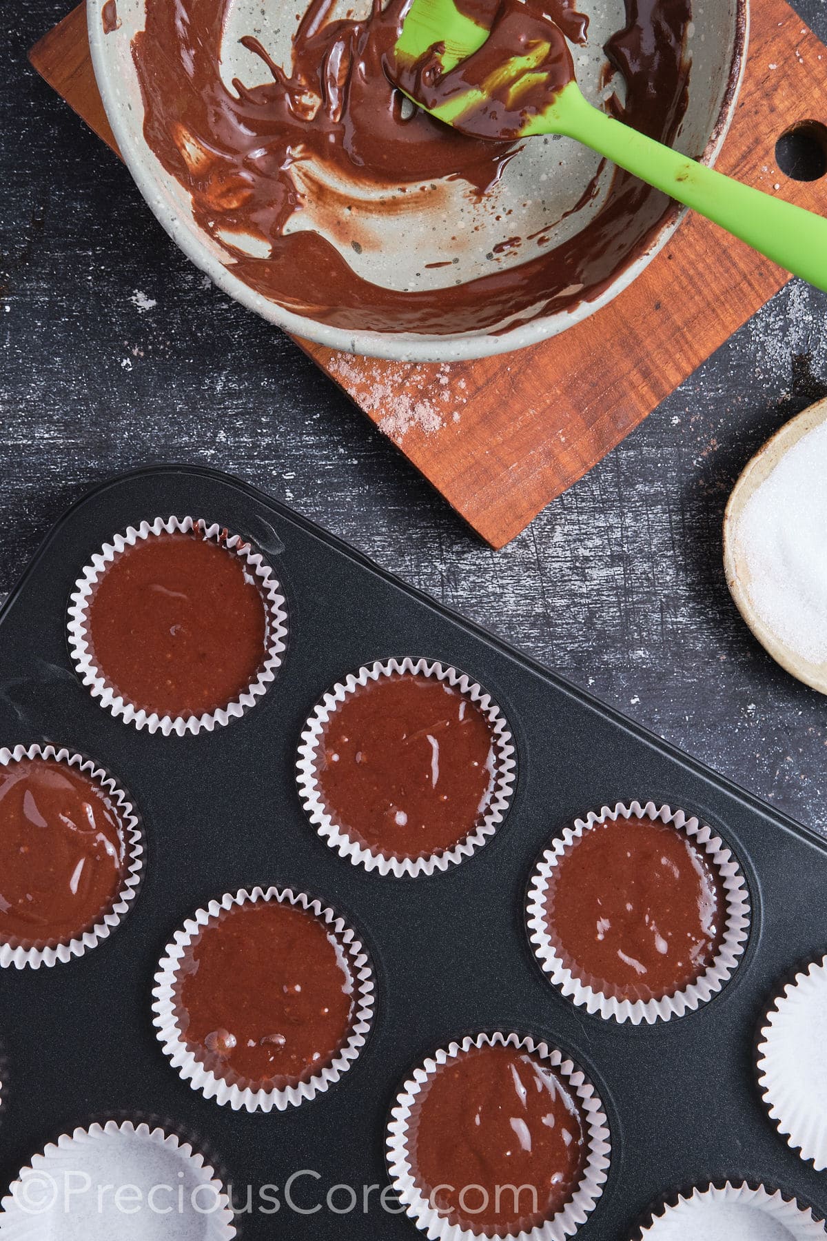 Chocolate cupcake batter in muffin pan ready for baking.